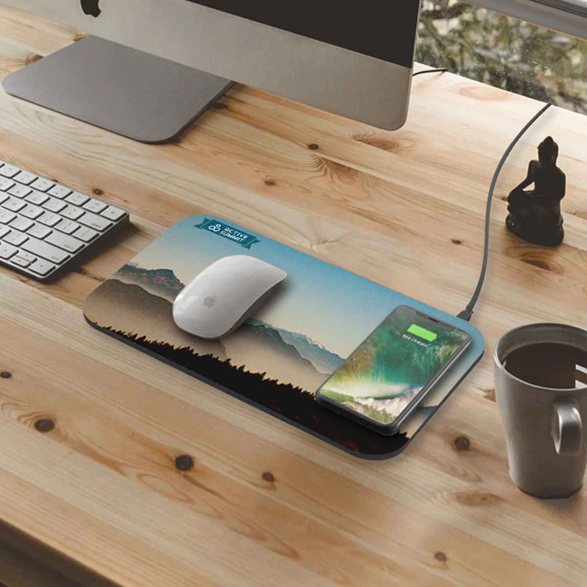 Wireless charging mousepad with full-color artwork charging a phone on a desk